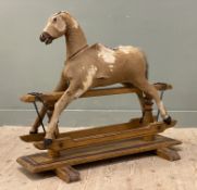 An early 20th century rocking horse, genuine hide body with horse hair stuffing to interior, on a