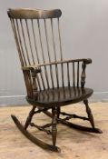 A late 19th century elm and ash Windsor armchair, spindle back and scrolled arms raised on rocking