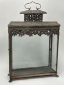 A decorative rustic garden lantern of rectangular form, decorated with pierced foliate detail to top