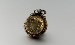 An Edwardian gold backed and front circular engraved portrait locket with ribbon and loop top: d.