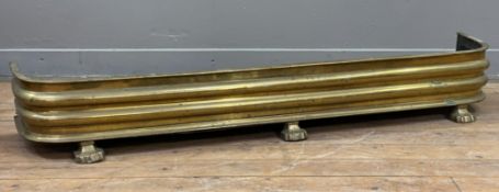 A Victorian brass fire fender, rounded edges and raised on lion's paw supports: H. 22cm L. 139cm