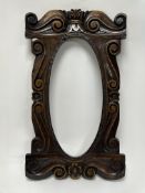 An early 20thc carved mahogany mirror frame/picture frame, with central oval space and carved