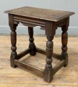 A 17th century-style oak stool, shaped apron raised on splayed turned supports and stretchers: H.