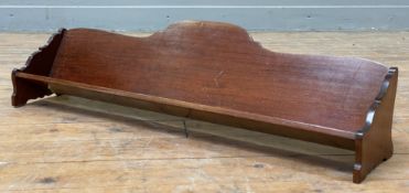 An Edwardian mahogany book trough, waterfall-shaped ends and bracket supports: H. 20cm L. 77cm