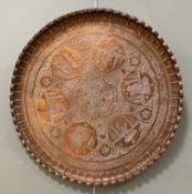 An early 20th century Indian copper tray, scalloped edge with embossed decoration featuring