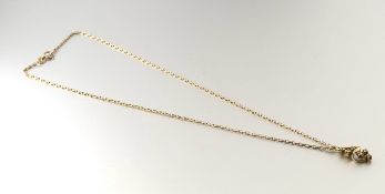 A 14k gold scrolling leaf pendant set six round brilliant cut diamond points: l. x 2cm 1.24g on a