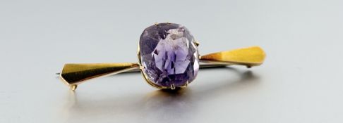 A yellow metal bar brooch set cushion cut faceted amethyst approximately 7.5ct: l. x 5.5cm stone: w.