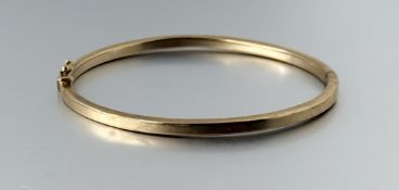 A 9ct gold stiff hollow bangle with clip fastening: d. x 6cm 5g