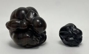 A graduated set of two Indonesian carved hardwood weeping Buddha figures, both carved of spherical