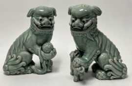 A pair of Chinese celadon glaze Foo Dogs, one modelled holding a ball, the other with a cub (a/f