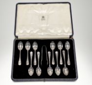 A George V London silver set of eleven tea spoons: l. x 10.5cm and matching pair of tongs, London