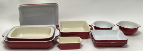 A collection of Emile Henry red stoneware dishes, comprising a pair of rectangular form, a pair of