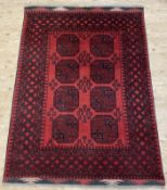 A hand-knotted Afghan Aqcha rug, central panel with eight large gul motifs enclosed within banded
