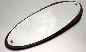 A Mid-20thc oval hall mirror, with mirror panel mounted on a stained wooden base. (l-73cm w-30cm)