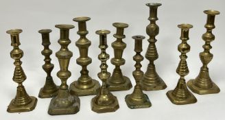 A collection of late 19th and 20thc assorted brass candlesticks, comprising a pair of baluster