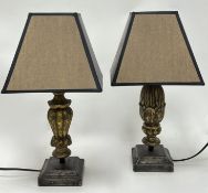 A near matched pair of gilded wooden table lamps, each carved with stylized leaf and acorn