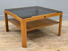 A mid-century teak coffee table by Myer, tinted glass inset top over shelf, raised on square
