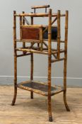 A Victorian bamboo magazine rack, brass caps over three dividers to top with inlaid and black