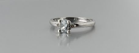 A 9ct white gold ring set oval faceted aquamarine approximately 0.25ct flanked by a diamond point to