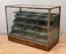 An early 20th century shop display cabinet, oak frame with glazed top and sides, complete with