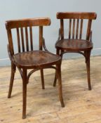 A pair of bentwood Thonet-style bistro chairs, curved and slat backs raised on splayed supports: