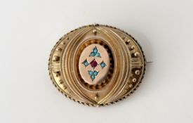 A Victorian yellow metal oval brooch with centre set with a pink old mine cut ruby flanked by