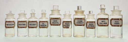 A group of ten clear glass apothocary jars with gilt and gilt verre eglomise labels, in various