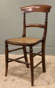 A Victorian mahogany and cane chair, curved bar back and splat with caned seat, raised on turned