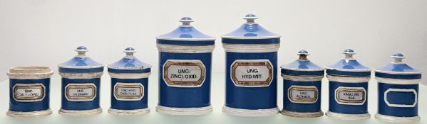 A group of eight Victorian blue and white lidded apothecary jars, with each raised glass covered red