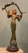 An Art Nouveau figural lamp by Alphonse Nelson, patinated metal with female figure raised on a