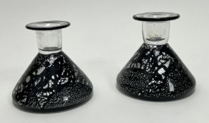 A pair of Roger Tye Studio Glass candle holders of conical form, with speckled black decoration (