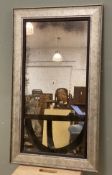 A modern rectangular wall mirror, rectangular faux-foxed plate enclosed within a silver antiqued