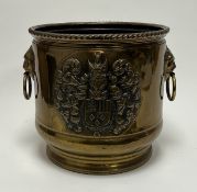 A large brass coal bucket/jardiniere with embossed coat of arms motif and twin lion head handles (h.