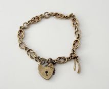 A 9ct gold knot link and round link chain bracelet with heart shaped padlock and a wishbone charm: