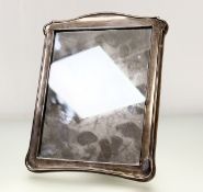A George V Birmingham silver table make-up mirror/ photograph frame with an arched top and oak