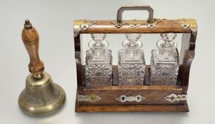 An early 20thc oak cased tantalus, with brass mounted features contaning three decanters with