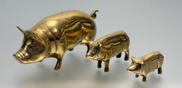 V A graduated trio of brass pigs (tallest h-8cm l-20cm smallest h-4cm l-18cm). (3)