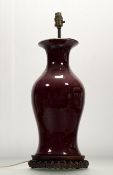 A Chinese Ox-Blood glazed ceramic baluster later converted table lamp, raised on a carved circular