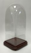 A Victorian glazed dome of square form, raised on four bun feet (h. 45cm)