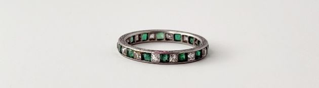 A white metal engraved bordered eternity ring set fourteen cushion cut emeralds, approximately 0.