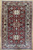 A fine hand-knotted Afghan Kazak rug, central field with three geometric medallions enclosed