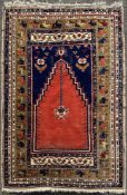 A hand-knotted Turkish prayer rug, central panel with stepped red mihrab on indigo blue field with