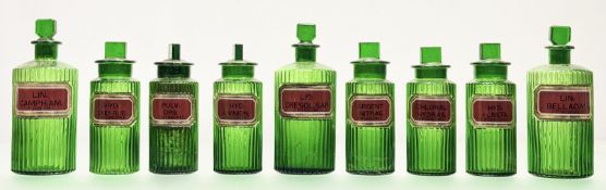 A group of nine 19th century fluted green glass apothecary jars, each with red and gilt verre