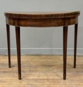 A George III mahogany demilune foldover card table, the plain top opening to a green baize-lined