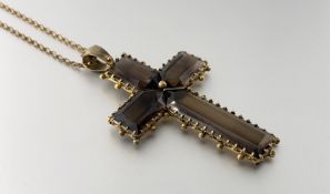 A late 19th century large gilt-metal mounted amber glass cross pendant, suspended from a gilt-