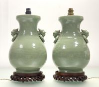 A pair of Chinese celadon-glazed Archaic style baluster form vases, each with a pair of ring 