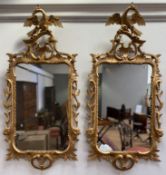 A pair of Rococo Revival giltwood mirrors, 20th century, each cartouche-shaped mirror plate within a