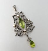 An Edwardian peridot and diamond pendant, claw-set to the centre with a navette-cut peridot within a
