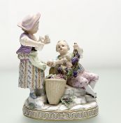 A 19th century Meissen porcelain group of a boy and girl harvesting grapes, on an oval base