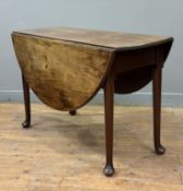 A George II mahogany pad foot drop-leaf dining table, mid-18th century, the oval top raised on